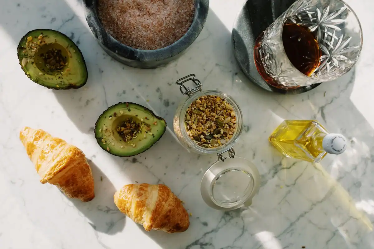 Avocado, croissante și semințe pe o masă de marmură, grăsimi de origine diferită