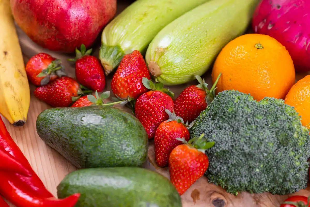 Fructe și legume proaspete pe o masă de lemn, alimentație variată alături de suplimente