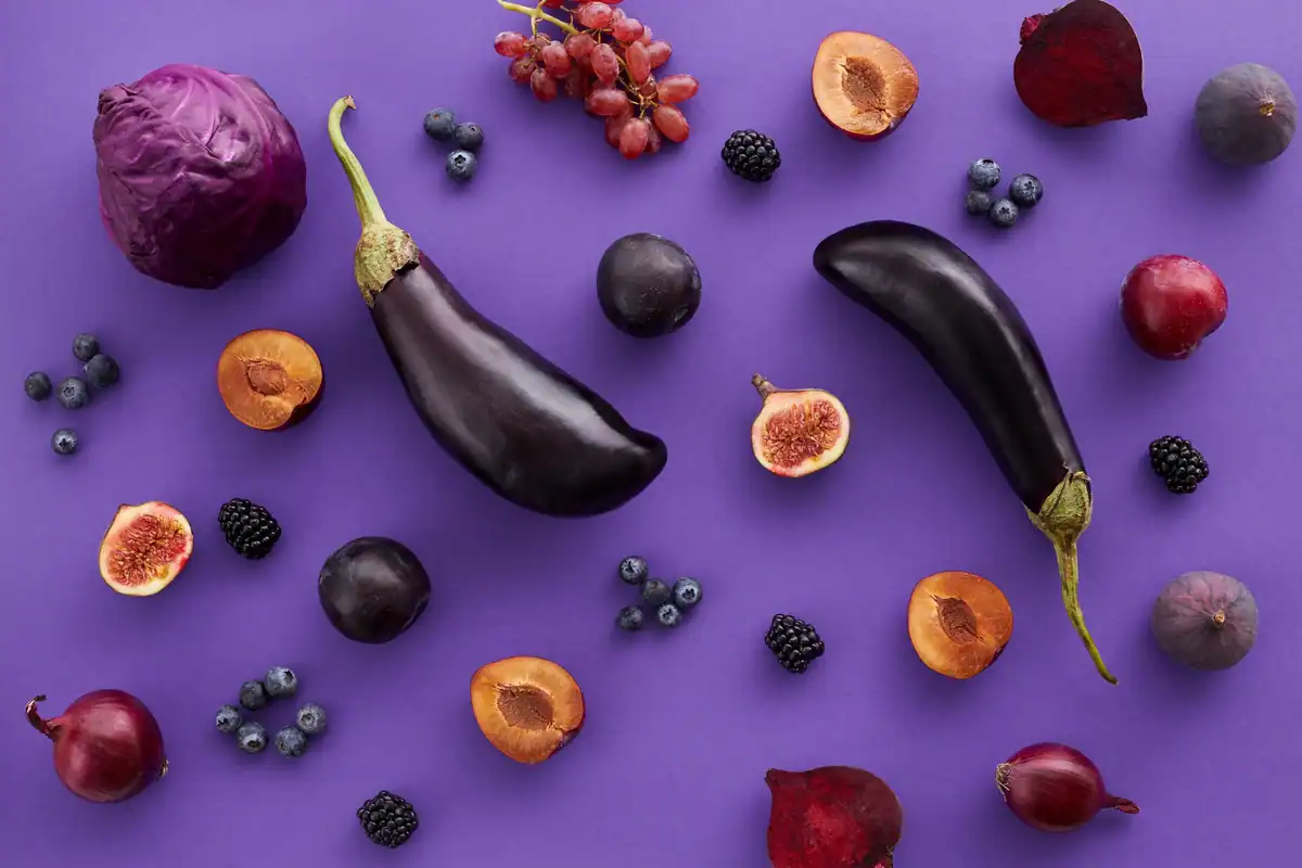 Vinete, smochine și prune pe un fundal violet, fructe și legume văzute de sus